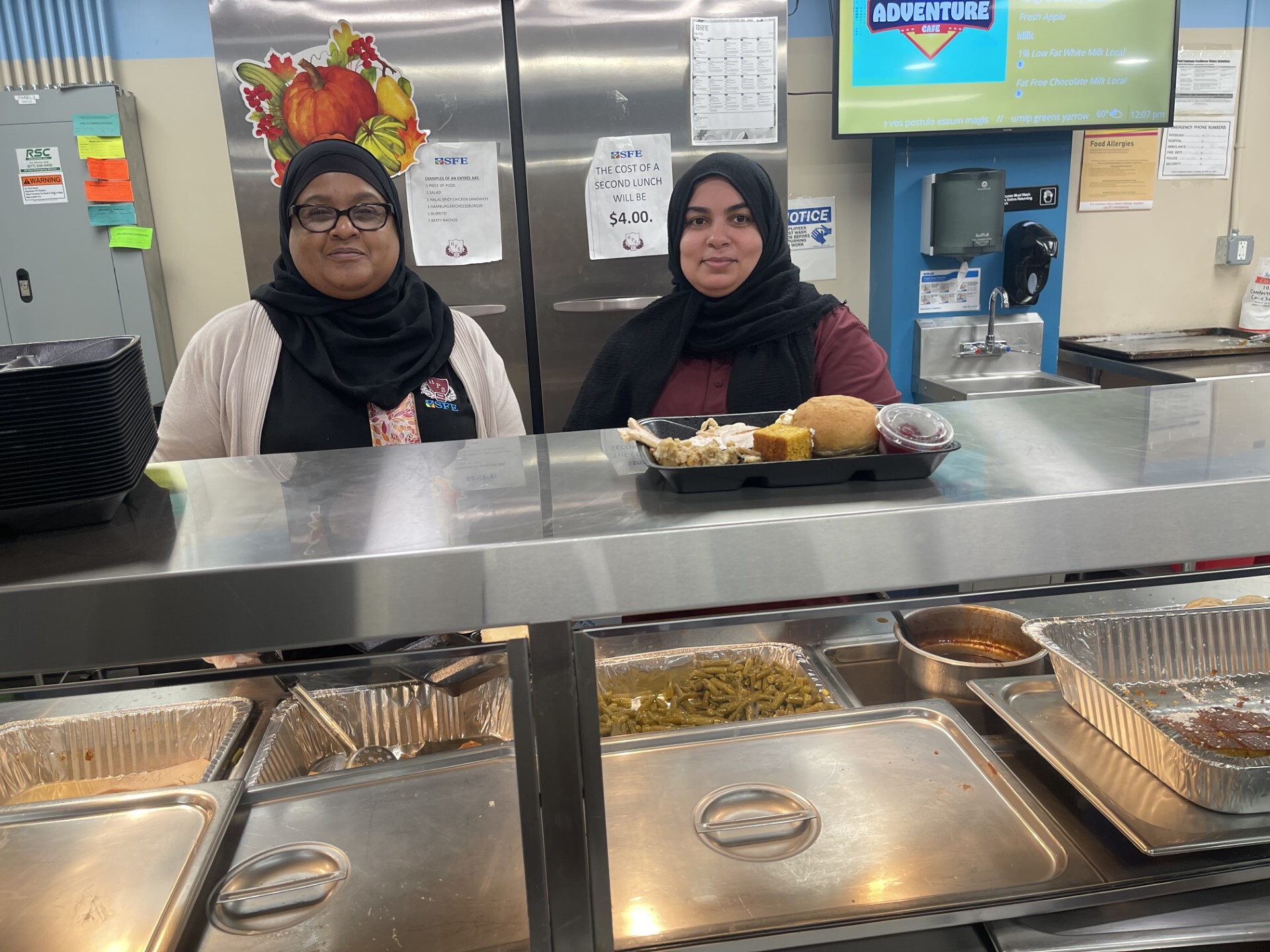 A photo of two workers serving lunch in one of our cafeterias.